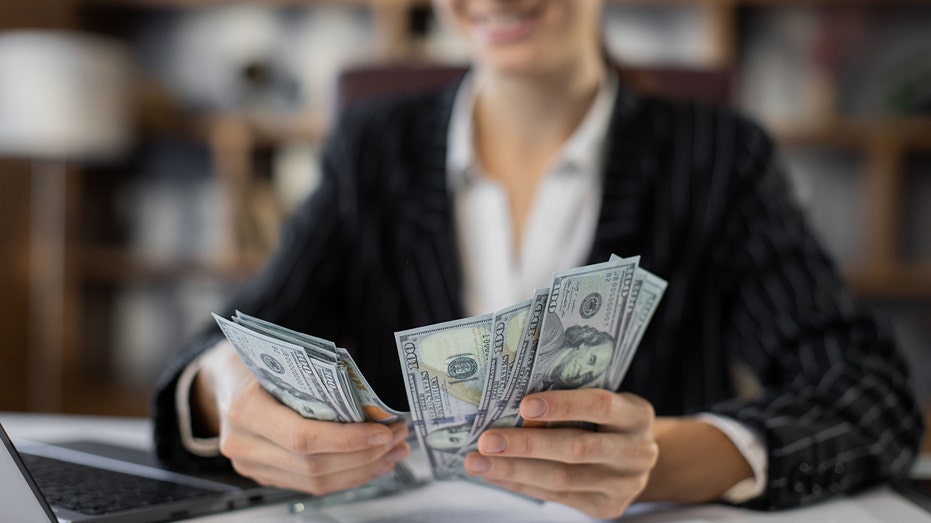 woman counting money at an office