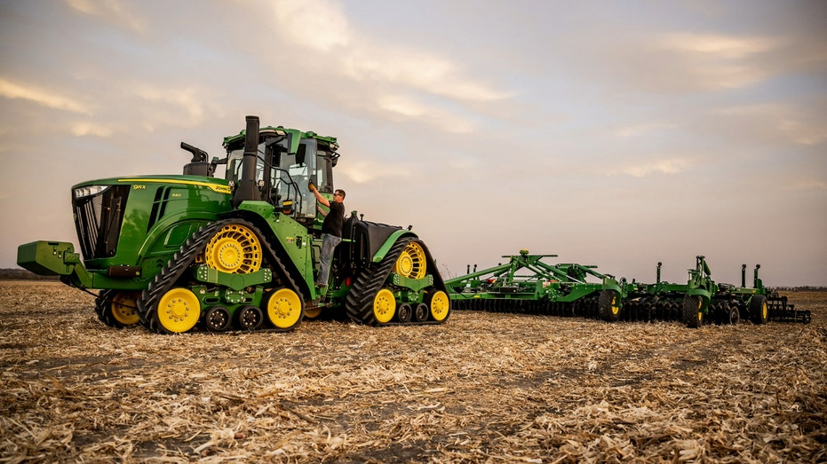 A farmer on a John Deere farm vehicle.