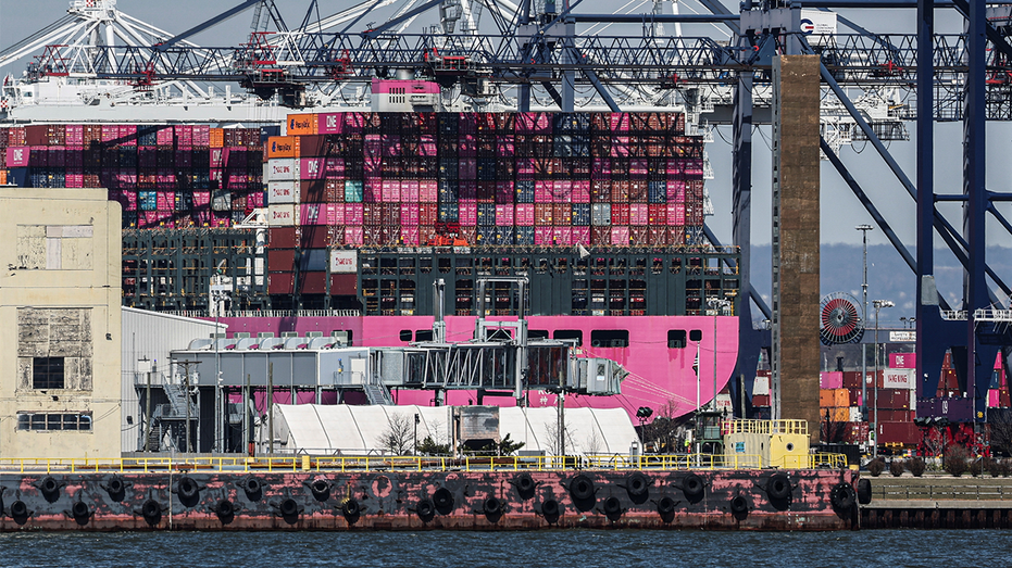 Containers are stacked on the deck of a cargo ship