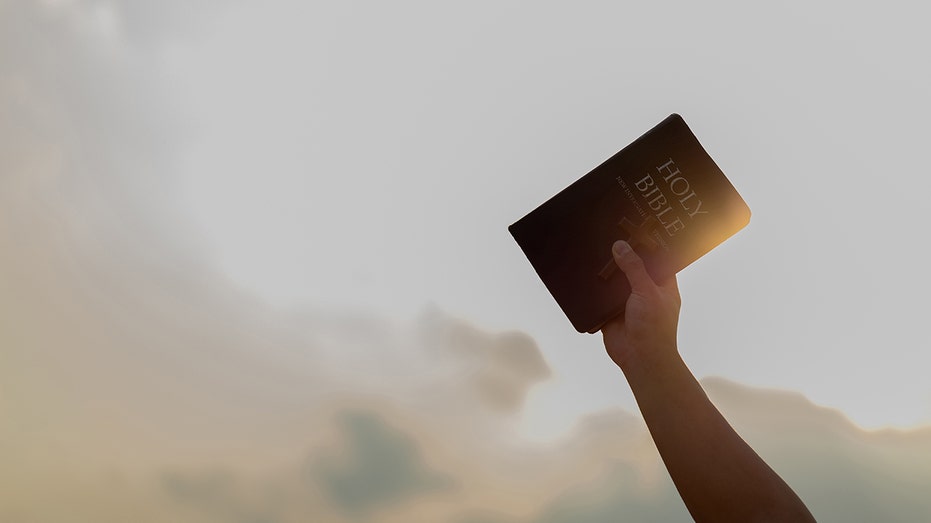 Stock photo of a Bible being held in the air