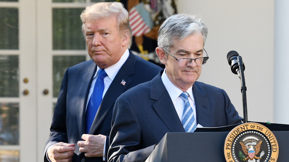 A photo of President Donald Trump walking behind Federal Reserve chairman Jerome Powell at the White House.