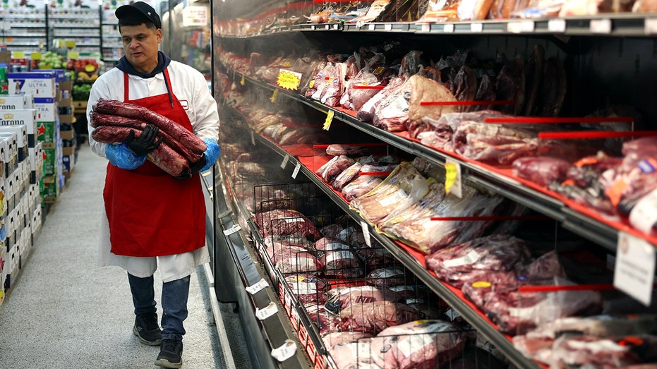 A man carries beef to the store shelf